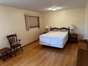 a bedroom with a bed and two chairs in it at Cozy Farmhouse B&B Retreat in Williams Lake