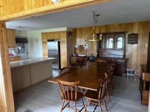 a kitchen and dining room with a wooden table and chairs at Cozy Farmhouse B&B Retreat in Williams Lake
