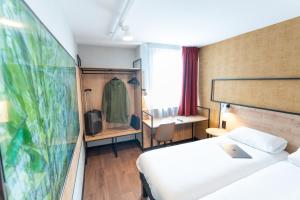 une chambre d'hôtel avec un lit et un bureau dans l'établissement Ibis Orleans La Chapelle Saint Mesmin, à La Chapelle-Saint-Mesmin