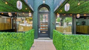 Un escaparate con una puerta negra y arbustos verdes. en The Nama Retreat, en Knoxville