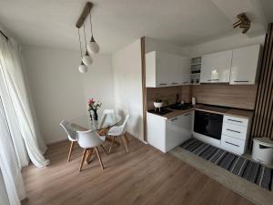 Una cocina con una mesa y sillas en una habitación. en Apartman I&I, en Kiseljak