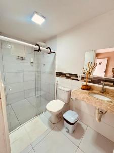 a bathroom with a toilet and a glass shower at Pousada Lampião Rio in Piranhas +35 photos
