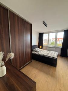a bedroom with a bed and a large window at Apartament w Centrum Miasta in Brodnica