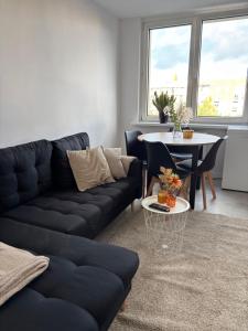 a living room with a black couch and a table at Apartament w Centrum Miasta in Brodnica