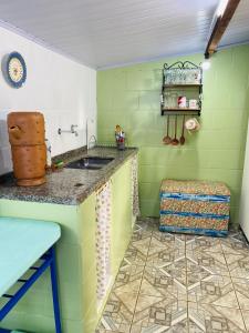 een groene keuken met een spoelbak en een kruk bij Casinha hibisco in Conceição da Ibitipoca