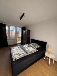 a bedroom with a black bed and a table at Apartament w Centrum Miasta in Brodnica +2 photos