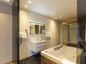 a bathroom with a tub and a sink at Movenpick Resort and Spa Fruske Terme in Vrdnik