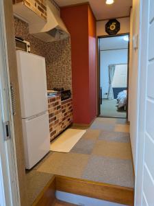 eine kleine Küche mit Kühlschrank und einen Flur in der Unterkunft Apartment Primeira Classe Room 1A - Vacation STAY 54531v in Imaichi
