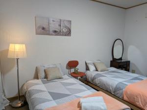 ein Zimmer mit zwei Betten und einem Lautsprecher an der Wand in der Unterkunft Apartment Primeira Classe Room 1A - Vacation STAY 54531v in Imaichi