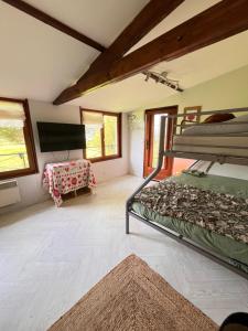 a bedroom with two bunk beds and a flat screen tv at La petite chambre in Mosnay