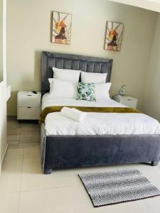 Un dormitorio con una cama grande con cabecero azul. en Selamu Accommodations, en Windhoek