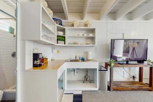a white kitchen with a sink and a desk at Kahaone Ohana (30+ night rental) in Waialua