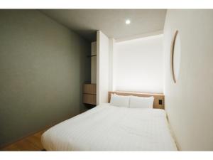 a small bedroom with a white bed with a window at HOTEL ALL IN Kumamoto - Vacation STAY 55107v in Hanabatachō +5 photos