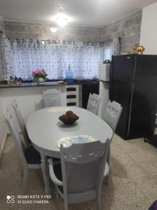 a kitchen with a white table and chairs and a kitchen with black appliances at Sweet beach apartment in San Felipe de Puerto Plata