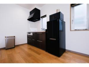 a kitchen with a black refrigerator in a room at HOTEL ALL IN Kumamoto - Vacation STAY 55117v in Hanabatachō