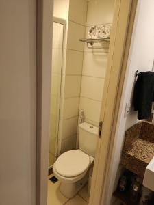 Un pequeño baño con inodoro y ducha. en Flat 519, en Macaé