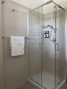 a shower stall with a glass door in a bathroom at Monolocale vicino Pordenone Fiera 