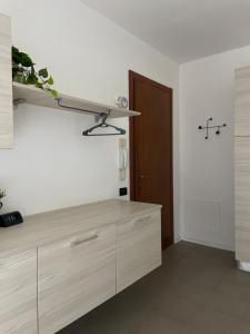 a kitchen with wooden cabinets and a brown door at Studio apartment near Pordenone Fiera 