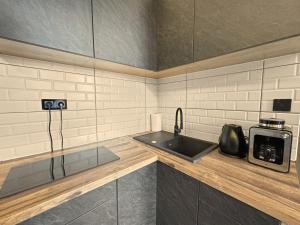 a kitchen with a sink and a microwave at Loft Apartment in Odorheiu Secuiesc +6 photos