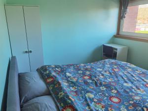 een slaapkamer met een bed met een deken erop bij Woodside room Glasgow in Glasgow