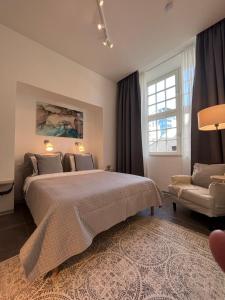 a bedroom with a large bed and a chair at Suite Nr 4 - J26 LUXURY APARTMENT, Jauniela 26 Old Riga - TOP Location - 2BDR - 80m2 in Rīga