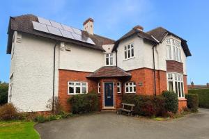 a large house with a solar panel on the roof at Spacious 4-Bed Home - Oswestry - Families & Groups in Oswestry