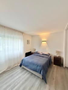 een slaapkamer met een bed en een groot raam bij Cozy studio in calm in Mandelieu-la-Napoule