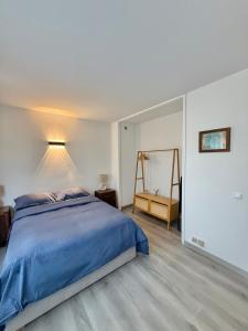 een slaapkamer met een blauw bed en een spiegel bij Cozy studio in calm in Mandelieu-la-Napoule