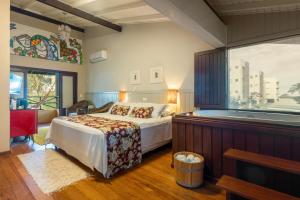 a bedroom with a bed and a bath tub at Pousada Vila Tamarindo Eco Lodge in Florianópolis +84 photos