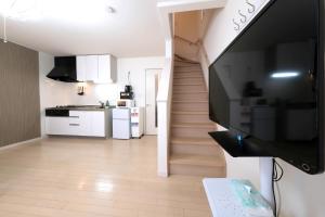 a living room with a television and a staircase at Kapalua East-Kapalua West - Vacation STAY 20388 in Tokyo