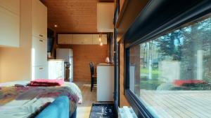 a bedroom in a tiny house with a large window at Les Chalets Horizon in Saint-Just-de-Claix