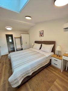 a large white bed in a bedroom with a desk at AdisiTi S1 in Zagreb