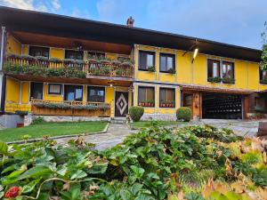Una casa amarilla con un balcón con plantas. en Hotel Rai, en Koprivshtitsa