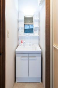 ein weißes Badezimmer mit Waschbecken und Spiegel in der Unterkunft AMP FLAT ARCBLISS 3 - Vacation STAY 57123v in Chikushino
