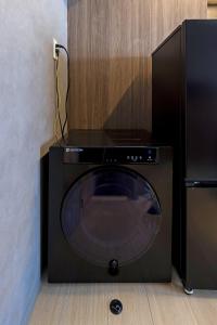 eine Mikrowelle neben einem schwarzen Geschirrspüler in der Unterkunft AMP FLAT ARCBLISS 3 - Vacation STAY 57123v in Chikushino