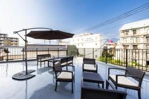 eine Terrasse mit Tischen und Stühlen und einem Sonnenschirm in der Unterkunft AMP FLAT ARCBLISS 3 - Vacation STAY 57123v in Chikushino