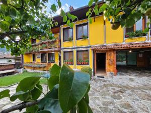 a yellow building with windows and a courtyard at Hotel Rai in Koprivshtitsa +35 photos
