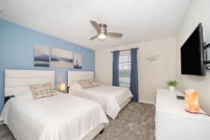 Un dormitorio con dos camas y un televisor de pantalla plana. en 4830FA TOWNHOUSE 4 BEDROOMS & 3 BATHROOMS + POOL, en Kissimmee 21 fotos más