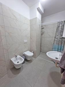 a white bathroom with a toilet and a sink at Mira Apartment in Tirana