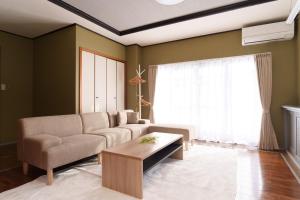 ein Wohnzimmer mit einer Couch und einem Couchtisch in der Unterkunft minka Villa Fujiyoshida - Vacation STAY 58146v in Funatsu