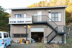 ein Haus mit einem Balkon und einer Garage in der Unterkunft minka Villa Fujiyoshida - Vacation STAY 58146v in Funatsu