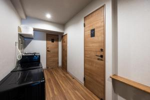eine kleine Küche mit Herd und Tür in der Unterkunft AMP FLAT ARCBLISS 2B - Vacation STAY 57408v in Chikushino
