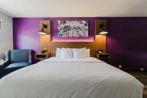 a hotel room with a large bed and a blue chair at La Quinta Inn by Wyndham Amarillo Mid-City in Amarillo +91 photos