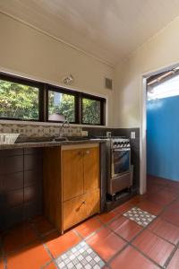 a kitchen with a sink and a stove at Pousada Vila Tamarindo Eco Lodge in Florianópolis