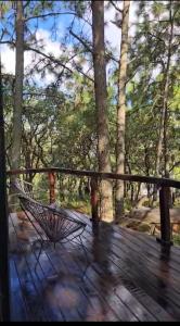 a hammock on a deck with trees in the background at La Cabaña 16 Mazamitla in Mazamitla +3 photos