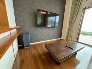 een woonkamer met een tafel en een spiegel bij Ocean View Mt, Kaimondake - Vacation STAY 58439v in Oka-chiyogamizu