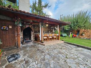 a patio with a stone fireplace and a table and chairs at Hotel Rai in Koprivshtitsa