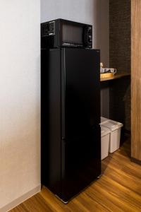 a black refrigerator with a microwave on top of it at AMP FLAT ARCBLISS 2A - Vacation STAY 57446v in Chikushino
