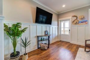 Una sala de estar con un televisor de pantalla plana en la pared. en Waterfront Holiday and Mardi Gras escape, en Bay Saint Louis