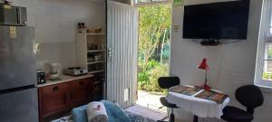 a kitchen with a living room with a table and a television at Opstal Herberg in Bredasdorp